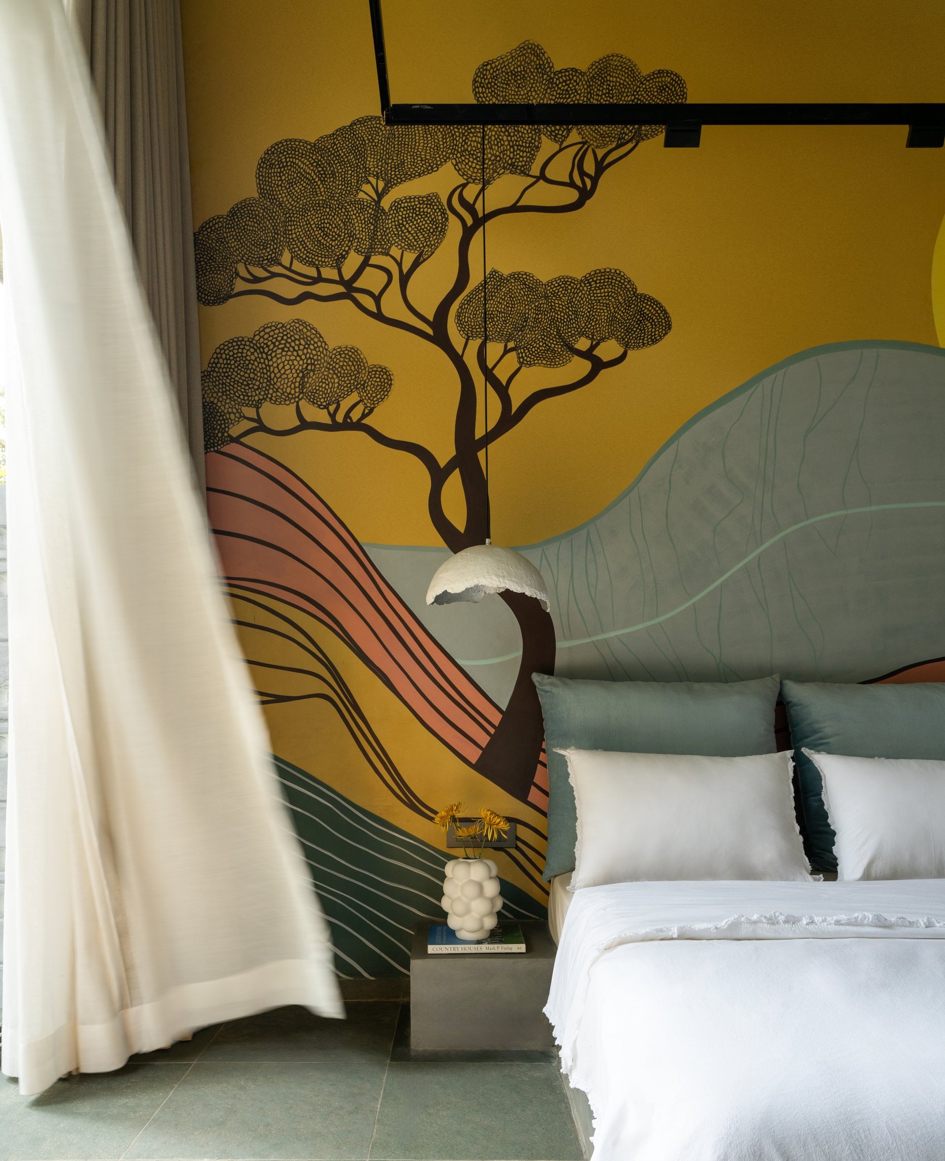 Morning light in a bedroom at SAHN, mural wall and linen