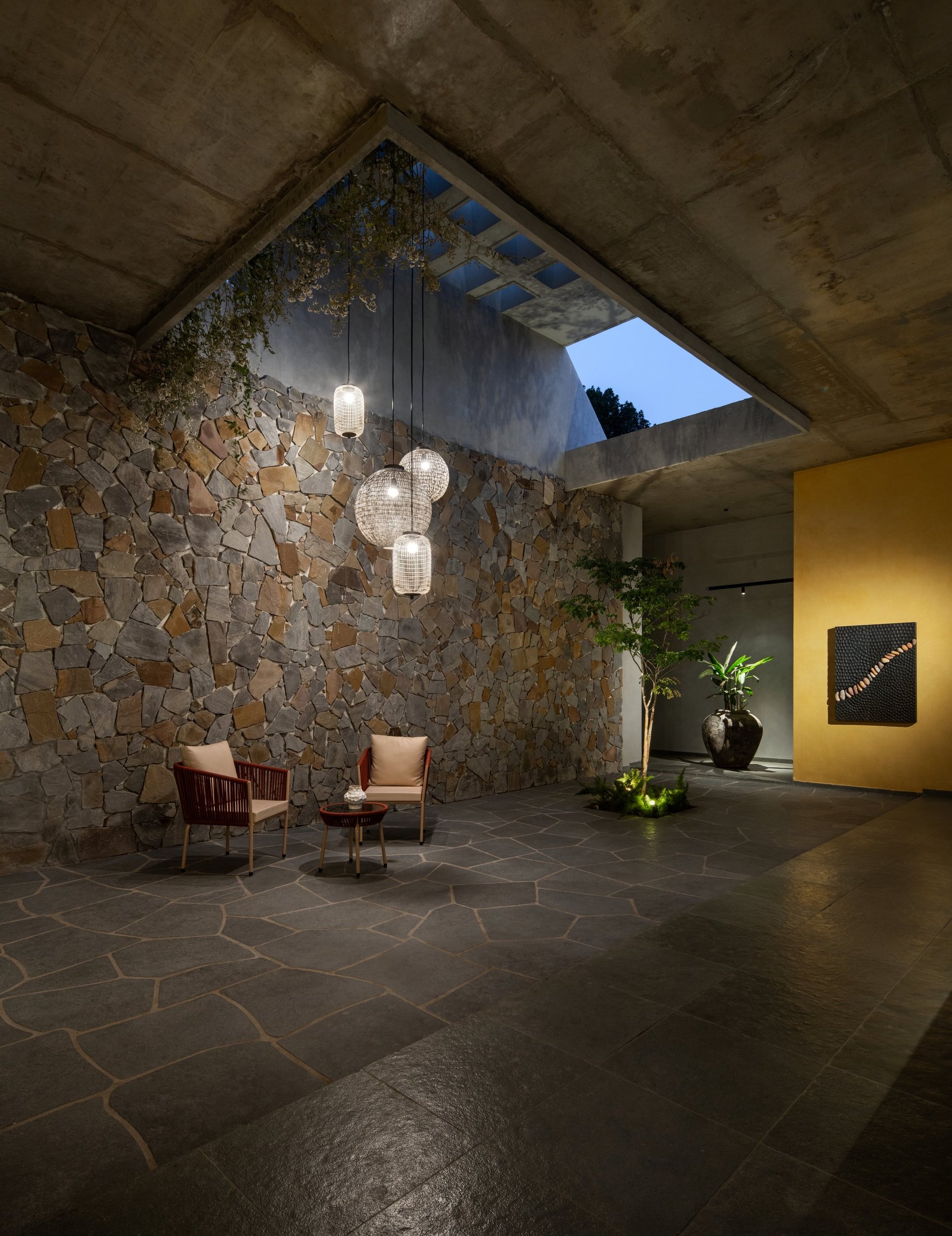 The stone-walled courtyard at SAHN at night, lanterns lit