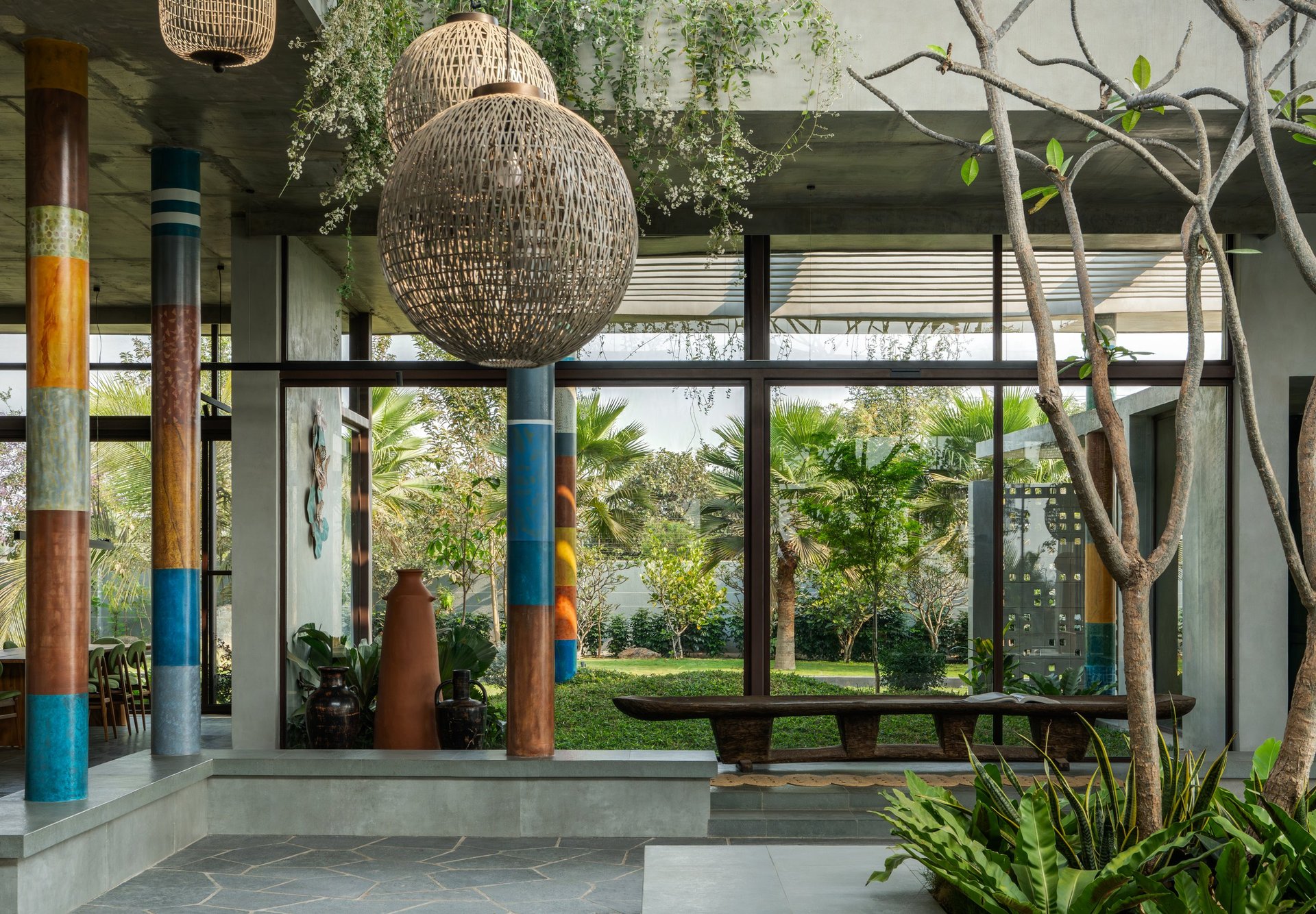 A courtyard at SAHN, lanterns above the table and the garden beyond